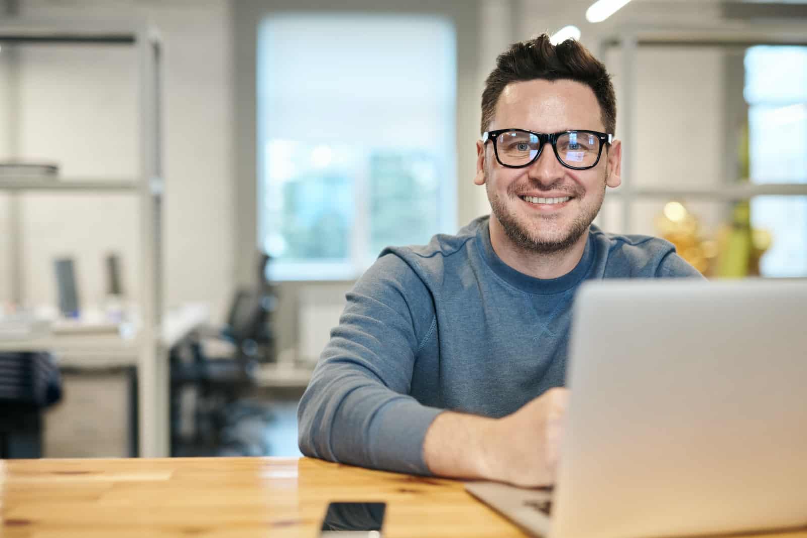 Photo of Man Wearing Eyeglasses while looking at his website